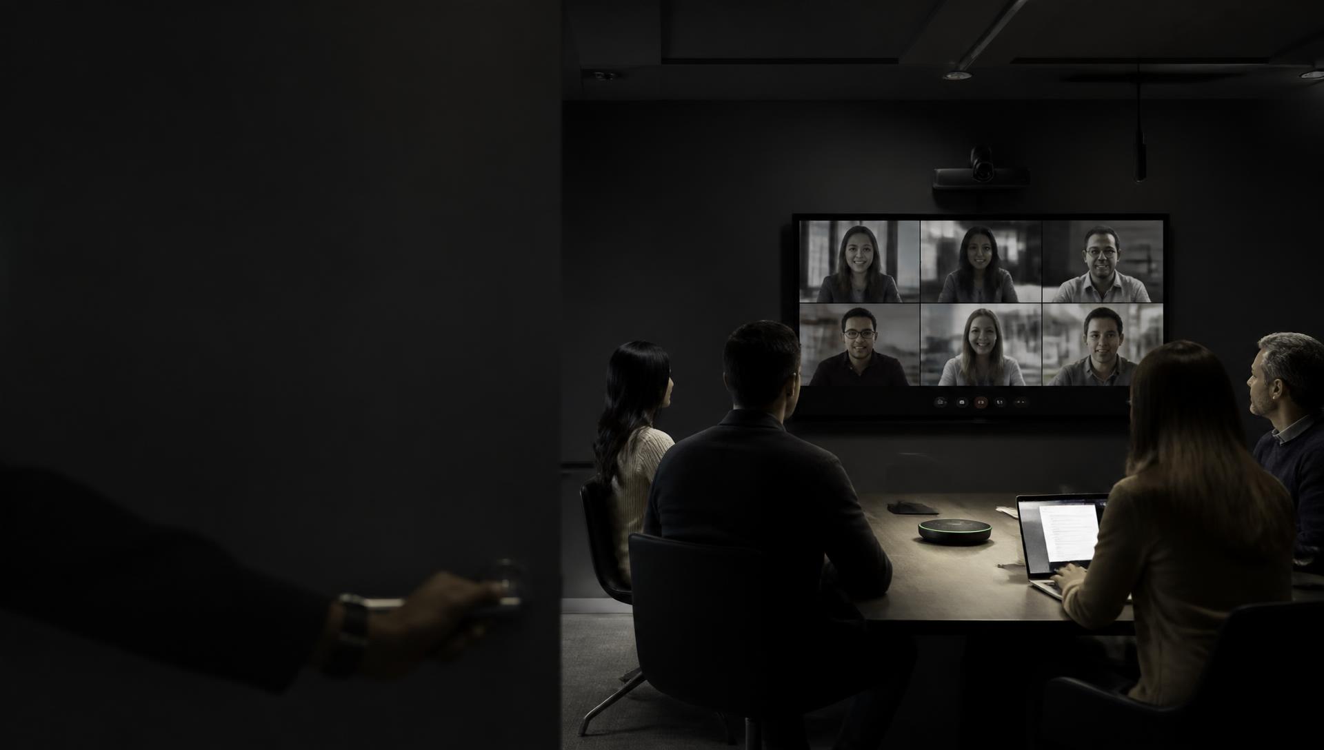Conference room with a team on a live video call, a conference speakerphone and a room camera